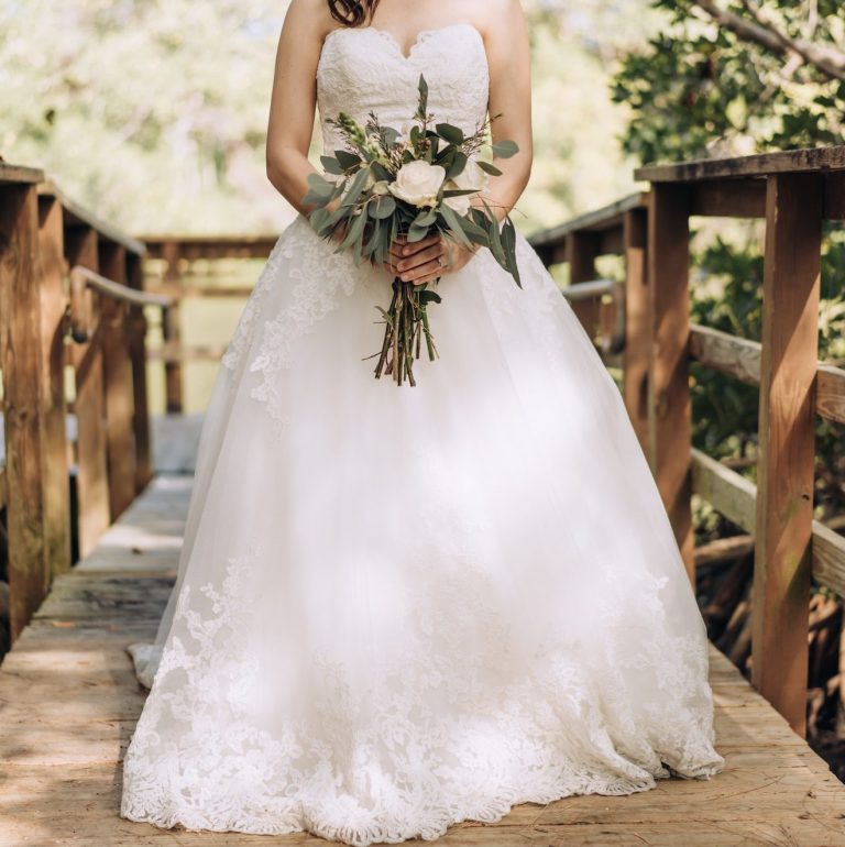 Bride in wedding dress holding flower bouquet waiting